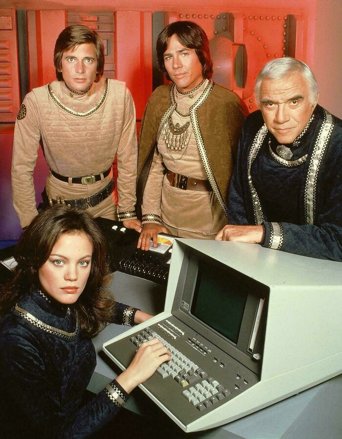 Cast from an old sci-fi show gathered around a vintage computer, evoking nostalgia and making you feel old as heck.