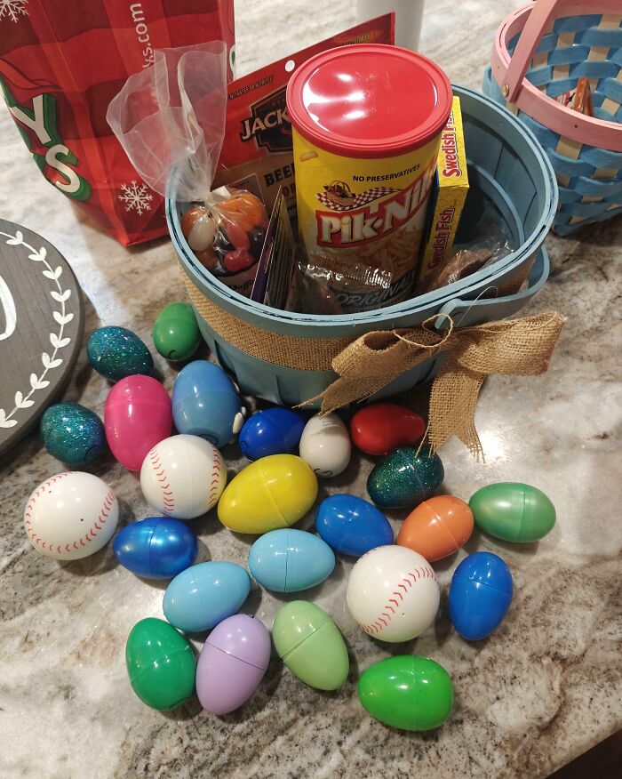 Colorful plastic eggs and snacks arranged in a festive basket, evoking happiness in moms and their wholesome moments.