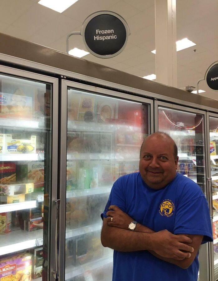 Man posing with a funny expression in front of a "Frozen Hispanic" sign, showing humor related to funniest parents.