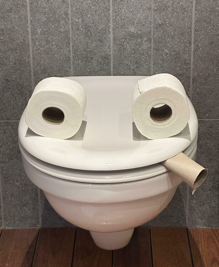 Toilet with two rolls of toilet paper placed as eyes and an empty roll as a mouth, showing funniest parents humor.