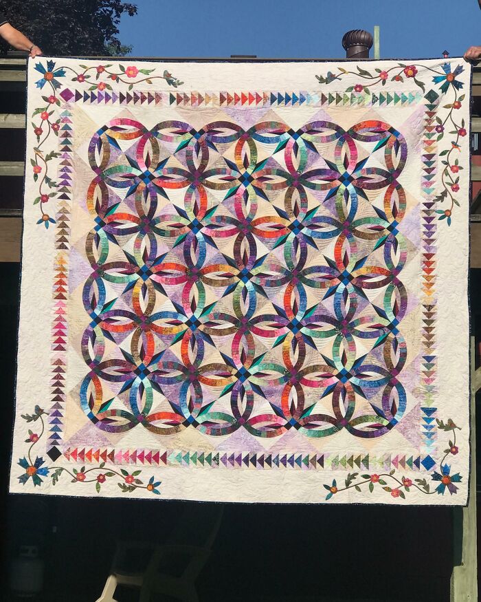 Colorful handmade quilt with intricate circular and floral patterns, showcasing the amazing wholesome creativity of moms.