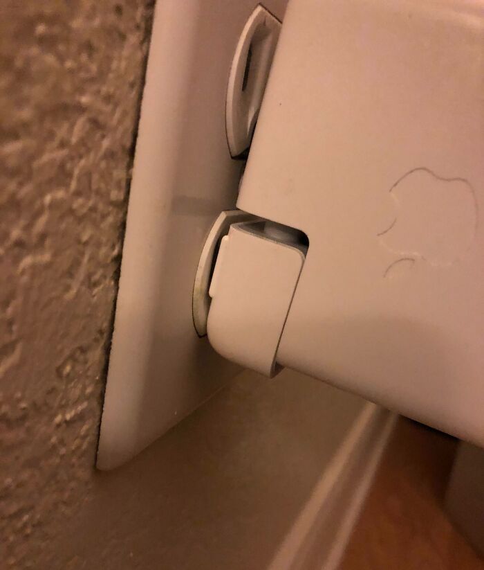 Misaligned power adapter barely fitting into a wall outlet showcasing bad luck on vacation shared in photos.