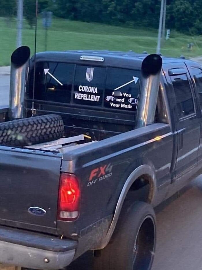 Black Ford FX4 off-road truck with large exhaust pipes and absurd scientific takes decal about corona repellent.
