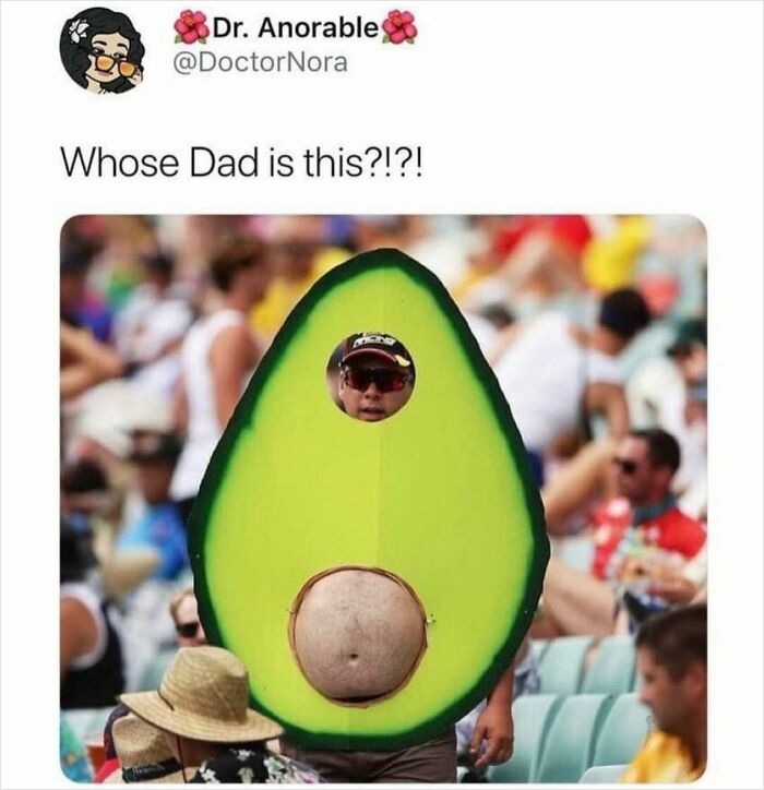 Man dressed in an avocado costume with belly showing at a crowded outdoor event, a men humor meme.