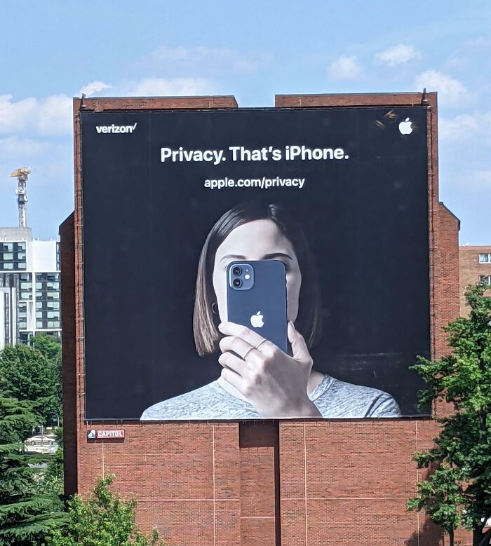 Large billboard in the US showing an iPhone privacy ad with a person holding the phone covering their face.