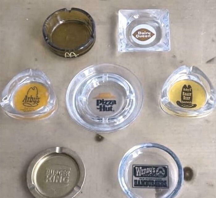 Collection of vintage fast food ashtrays from brands like Pizza Hut, Wendy's, Arby's, Dairy Queen, and Burger King evoking nostalgia.