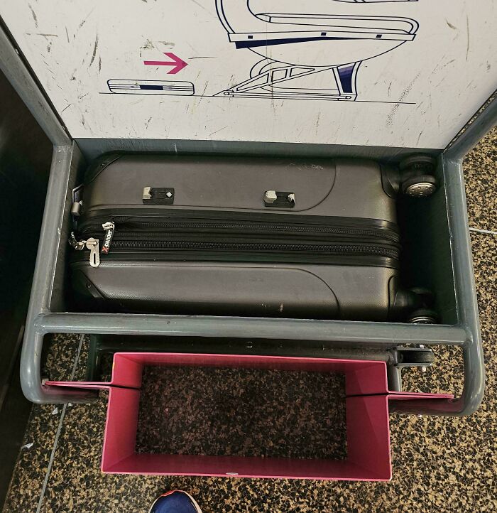 Suitcase placed in a luggage rack that is too small, illustrating people allergic to acting like sensible adults with poor design choices.