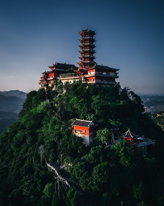 Ancient Asian temple complex atop a lush green mountain showcasing glimpses of everyday life in Asia.