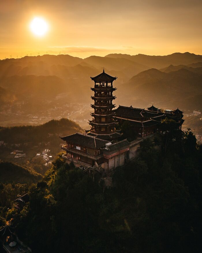 Ancient pagoda on a mountain at sunset, showcasing glimpses of everyday life in Asia with stunning landscape views.