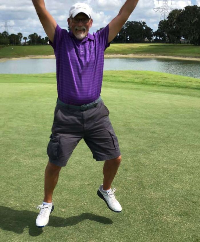 Man in purple shirt and white cap jumping with joy on a golf course in a funny and wholesome moment shared by kids
