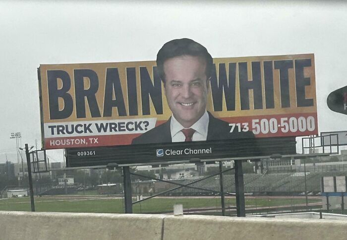 Funny and weird billboard in Houston featuring a lawyer with a clever truck wreck advertisement on a large roadside sign.