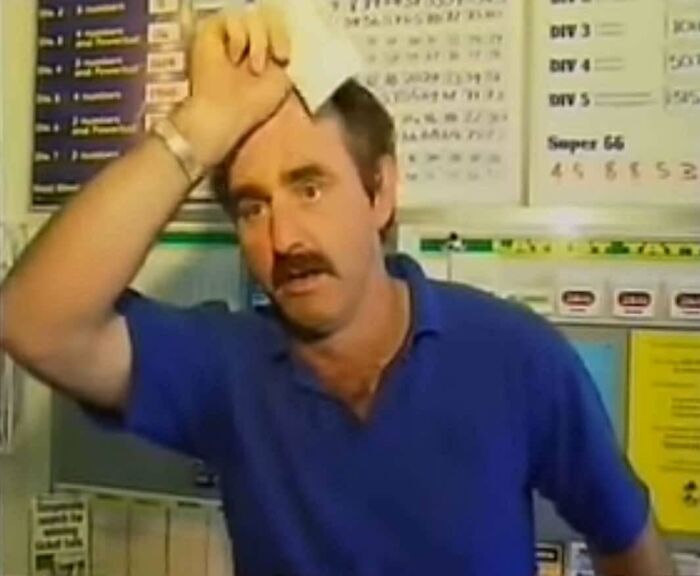 Man in blue shirt wiping sweat from forehead in front of a board, illustrating inspiring facts better than watching news.