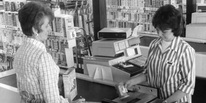 Two women in a vintage store setting using an old cash register illustrating inspiring facts better than news.