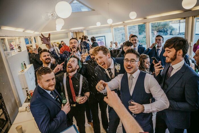 Group of men in suits celebrating at an indoor event capturing the moment the rope broke before disaster struck.