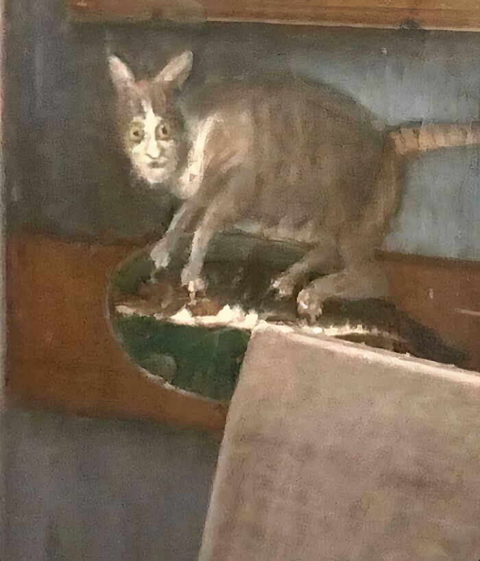 Medieval cats depicted in a historic painting with a human-like face, showcasing early artistic obsession with cats.