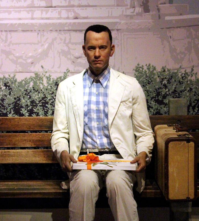 Man in a white suit sits on a bench holding a gift box, illustrating famous historical quotes often misunderstood.