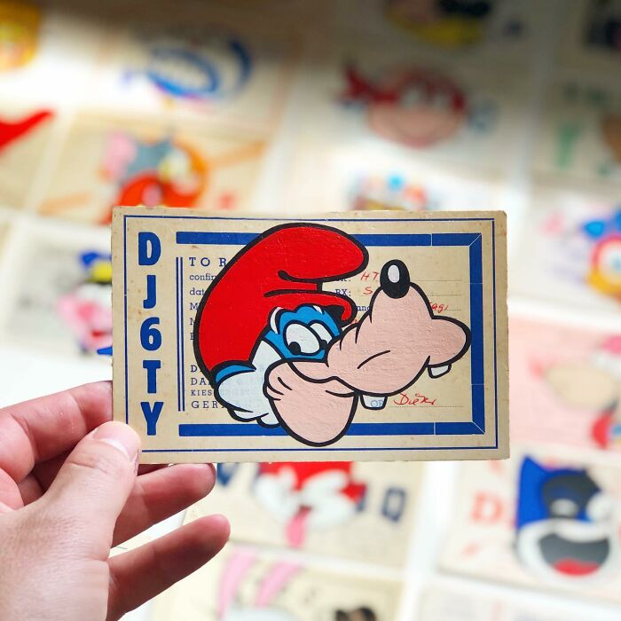 Hand holding artwork featuring a pop culture and cartoon character mash-up in the style of pop mash.