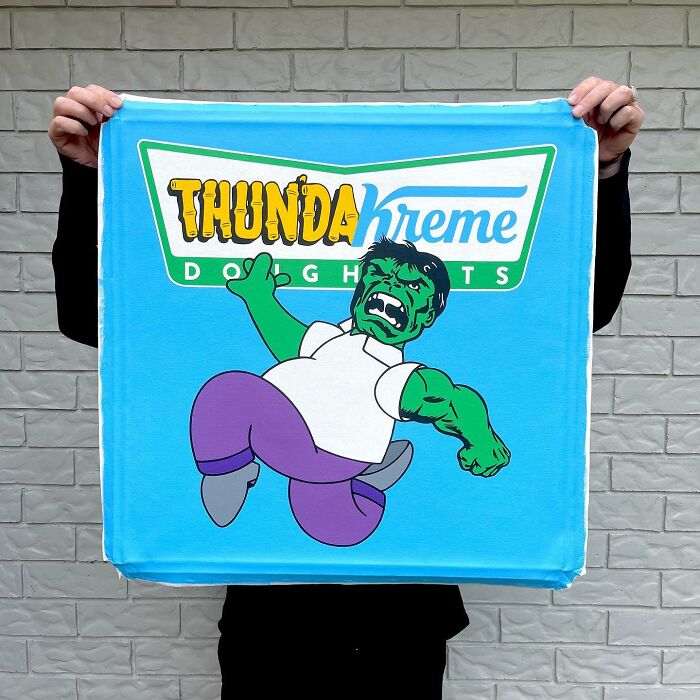 Person holding a blue fabric featuring a pop culture and cartoon character mash-up with the text Thundakreme Doghnuts.