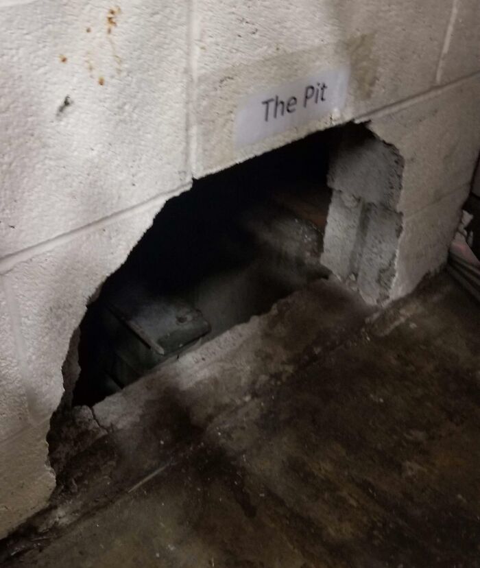Creepy and unsettling work environment showing a damaged wall labeled The Pit with a dark hole underneath.