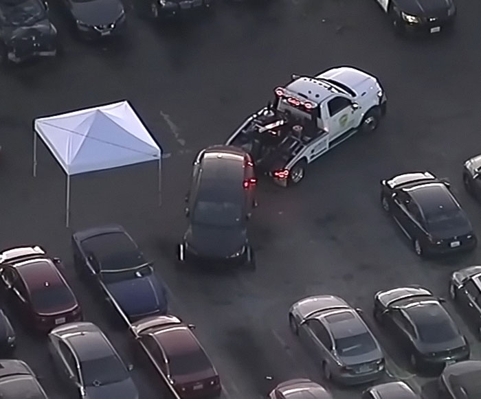Tow truck removing a Tesla registered to singer at a parking lot after decomposing body was found inside the abandoned vehicle. Tow truck removing a Tesla registered to singer at a parking lot after decomposing body was found inside the abandoned vehicle.
