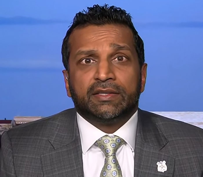Man in gray suit and patterned tie speaking on camera with FBI badge pin, related to Tyler Robinson Charlie Kirk case. Man in gray suit and patterned tie speaking on camera with FBI badge pin, related to Tyler Robinson Charlie Kirk case.