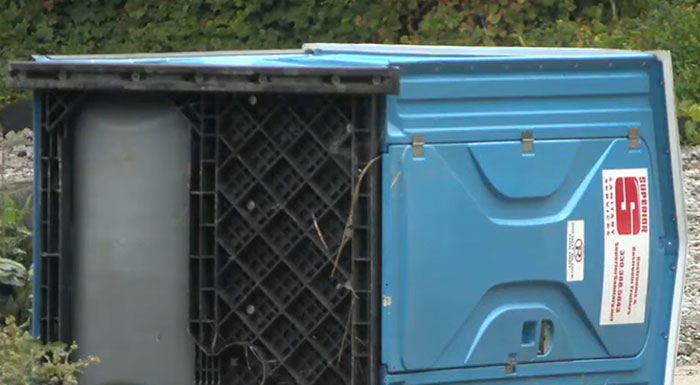 Blue porta-potty lying on its side outdoors, linked to a cop shooting incident involving teens over prank dispute. Blue porta-potty lying on its side outdoors, linked to a cop shooting incident involving teens over prank dispute.