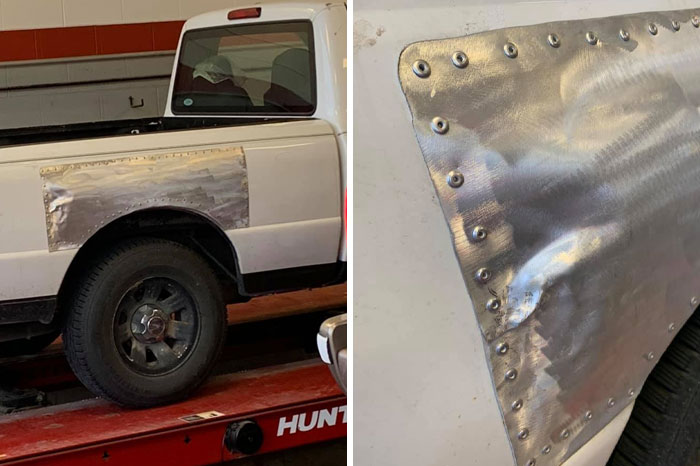 Car mechanics documenting a dented and riveted metal patch on a white truck fender for repair evidence.