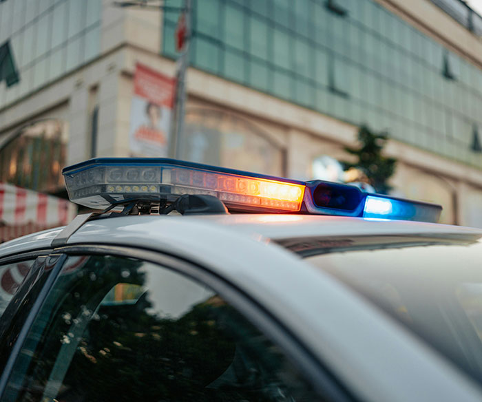 Police car with flashing lights parked on a city street related to diabolical couple arrested for hotboxing incident. Police car with flashing lights parked on a city street related to diabolical couple arrested for hotboxing incident.