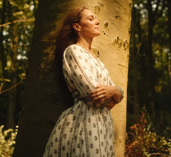 Kate Middleton in a patterned dress standing peacefully by a tree, reflecting after the royal funeral for King Charles. Kate Middleton in a patterned dress standing peacefully by a tree, reflecting after the royal funeral for King Charles.