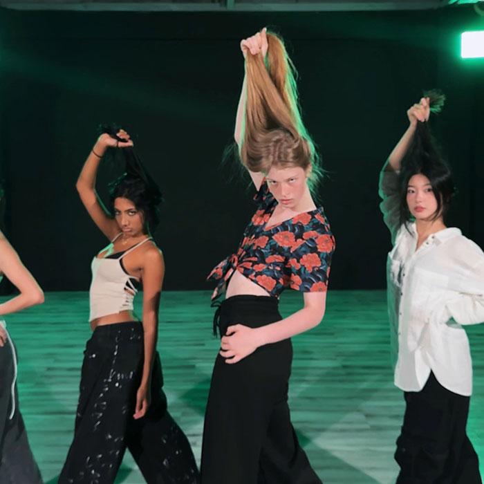 Three young women posing indoors, with one holding her long hair up, illustrating a diverse roommate setting. Three young women posing indoors, with one holding her long hair up, illustrating a diverse roommate setting.