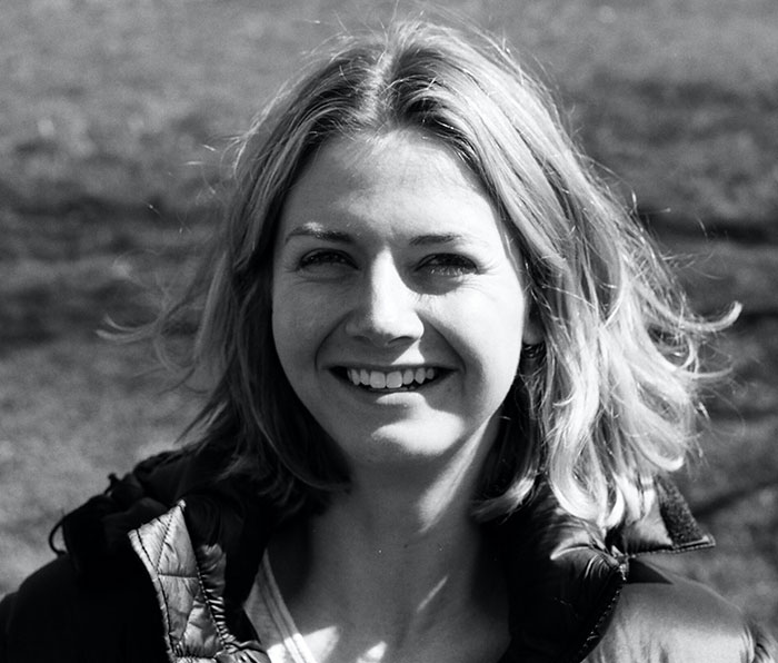 Smiling woman outdoors in a casual jacket representing Brooklyn midwife’s dice game club safety concerns for non-white women.