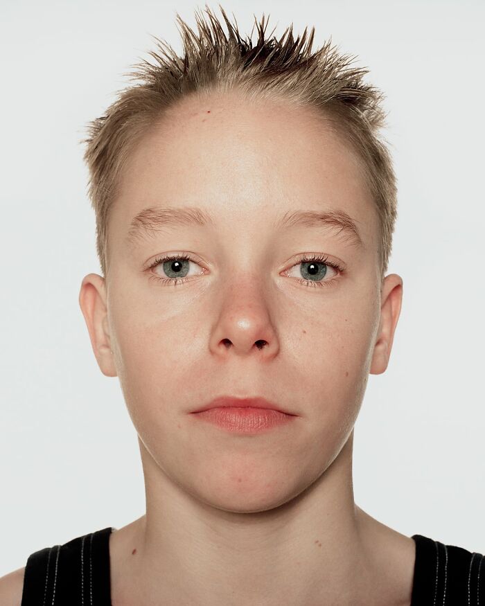 Close-up portrait of a young boxer with spiked hair, showing determination before their first match in powerful photographs.