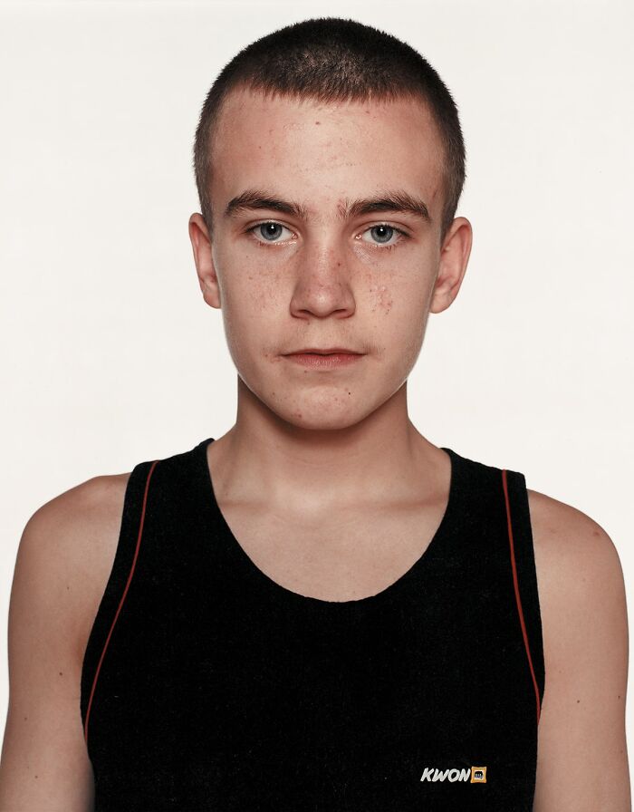 Young boxer with a serious expression wearing a black sports tank top in a powerful portrait before his first match