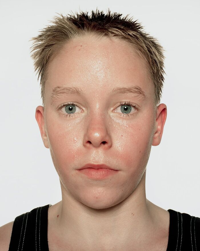 Close-up portrait of a young boxer with spiked hair, showing determination before their first match in powerful photographs.