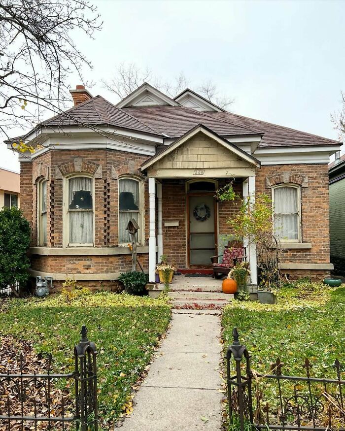 Cozy old home with brick exterior, front porch, and autumn decorations, showcasing adorable and lovely old homes charm.