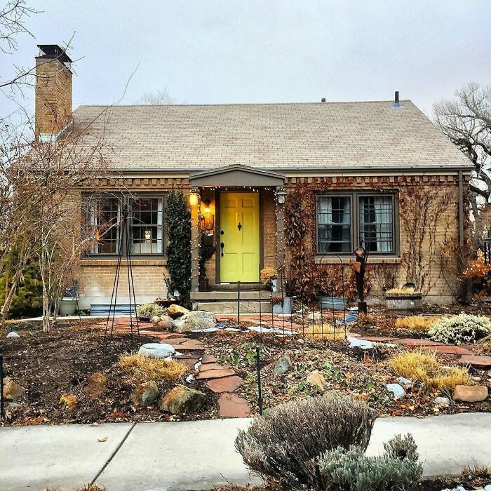 Charming old home with yellow door and rustic garden, showcasing adorable and lovely old homes ideal for moving in.