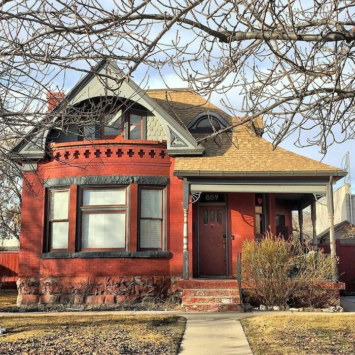 Charming old brick home with unique architectural details and a cozy front porch in a quiet neighborhood.