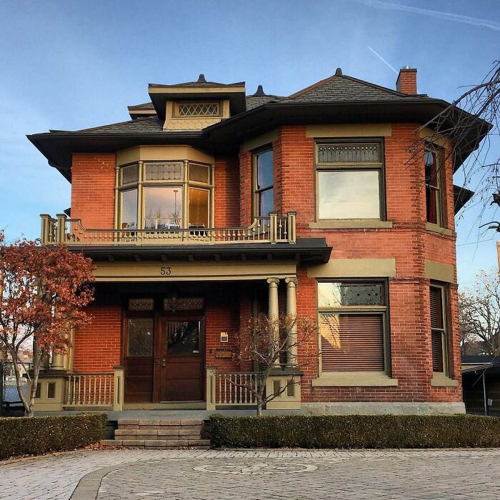 Victorian-style old home with red brick exterior, bay windows, and charming architectural details, perfect for lovers of old homes.