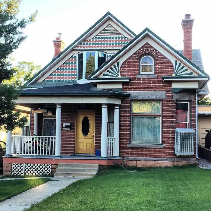 Charming old home with brick exterior, decorative gable patterns, front porch, and well-maintained lawn in a residential neighborhood.