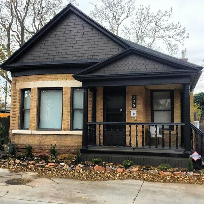 Charming old home with brick exterior and black trim, cozy front porch, and neat landscaping, perfect for lovely old homes enthusiasts.