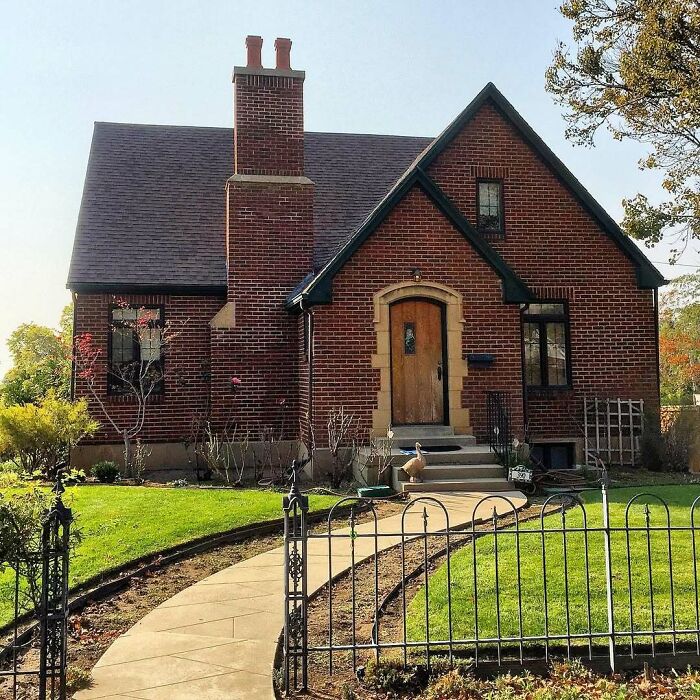 Charming old brick home with a curved pathway and lush green lawn, perfect for those seeking lovely old homes to move into.