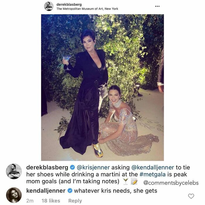 Kris Jenner in a black dress raising a martini glass while Kendall Jenner kneels tying her shoes at a celeb event.