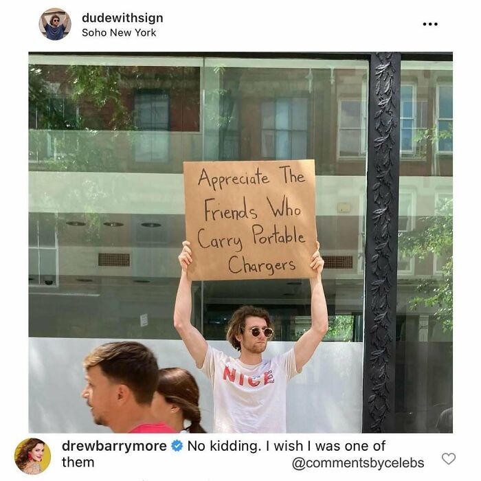 Man holding sign appreciating friends who carry portable chargers, a relatable moment in celeb comments and unexpected gems.