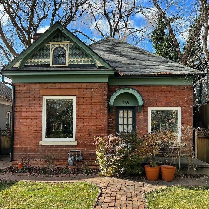 Charming old home with brick exterior, green trim, and quaint front yard, showcasing adorable and lovely old homes appeal.