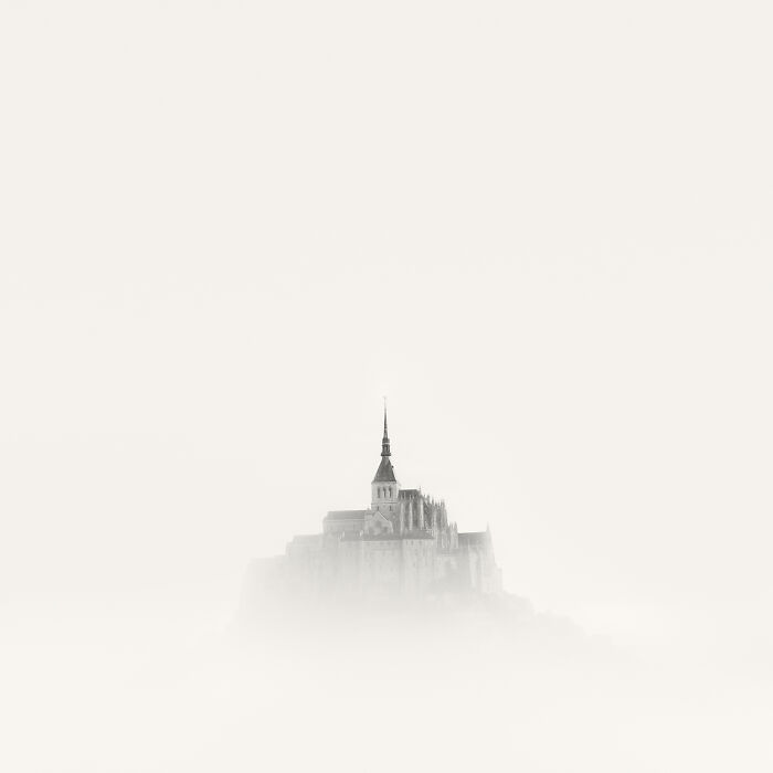 Black and white photo of a historic church spire emerging from soft mist, awarded in 2025 Exposure One Awards.