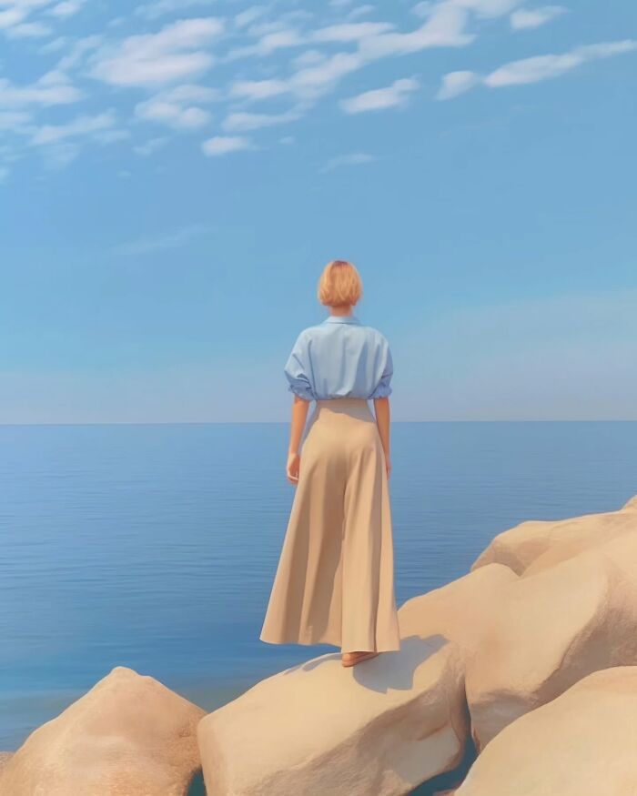 Woman standing on rocks by calm sea under blue sky, minimalist photo evoking a peaceful escape and dreamy atmosphere.