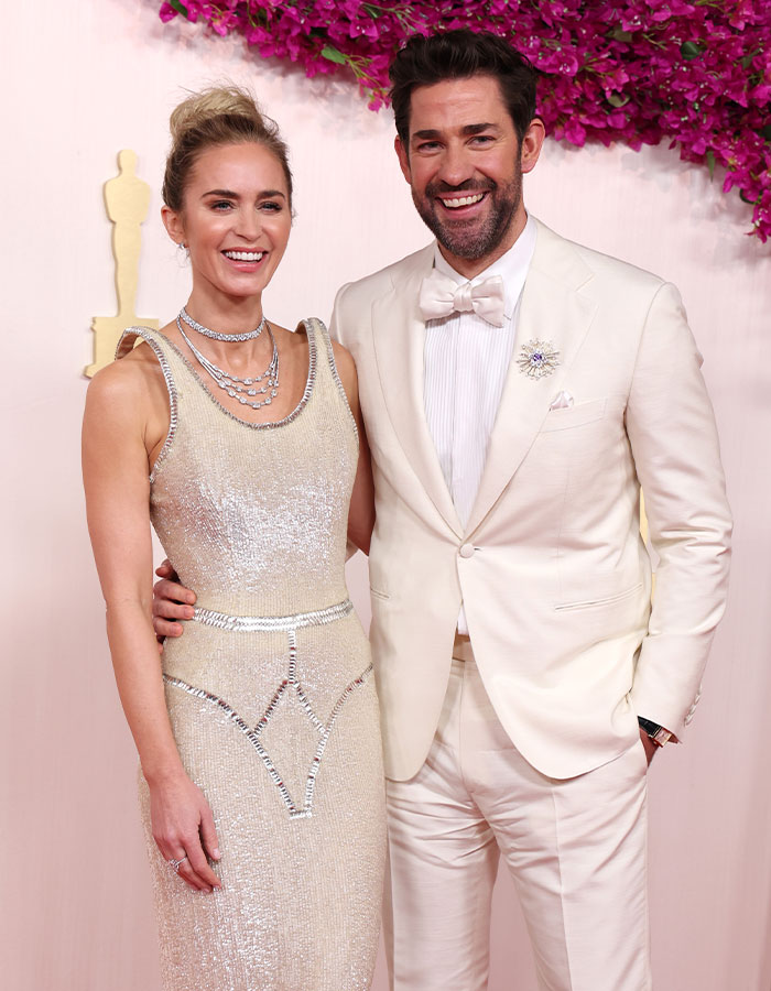 Emily Blunt posing in a shimmering dress with a braless look, sparking plastic surgery rumors at an event. Emily Blunt posing in a shimmering dress with a braless look, sparking plastic surgery rumors at an event.