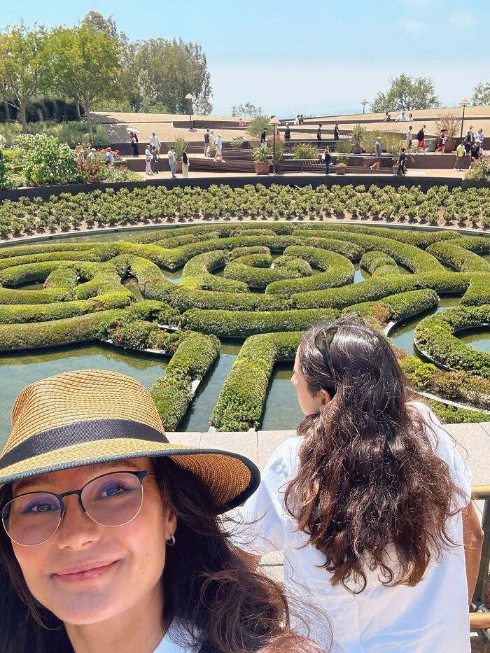 Two women smiling near a garden maze with greenery, illustrating Bruce Willis' wife defending moving him out amid dementia. Two women smiling near a garden maze with greenery, illustrating Bruce Willis' wife defending moving him out amid dementia.