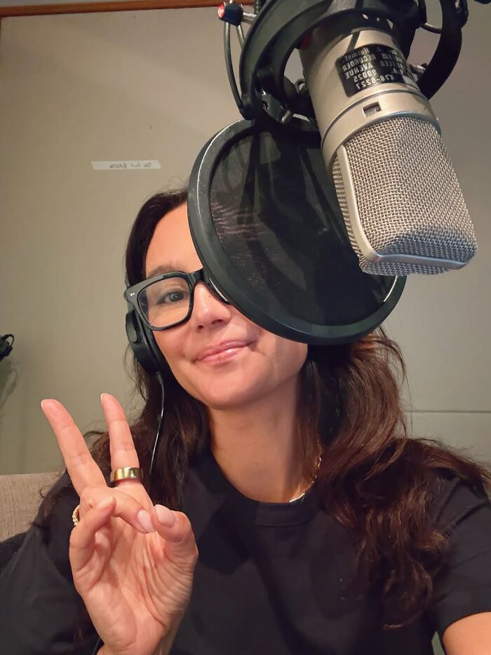 Woman wearing headphones and glasses giving a peace sign in a recording studio, related to Bruce Willis' dementia battle. Woman wearing headphones and glasses giving a peace sign in a recording studio, related to Bruce Willis' dementia battle.