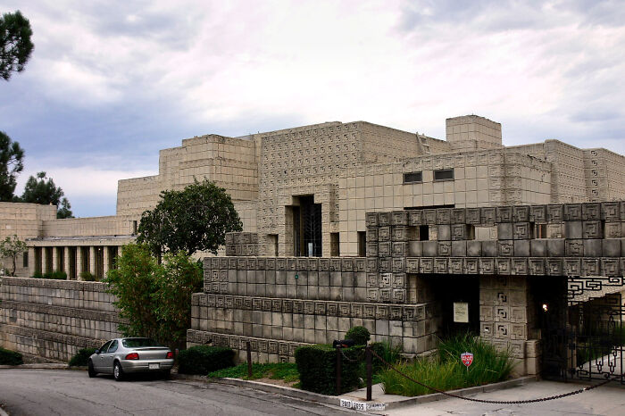 Modern concrete TV house exterior with geometric patterns on a hillside, showcasing iconic TV houses existing in real life.